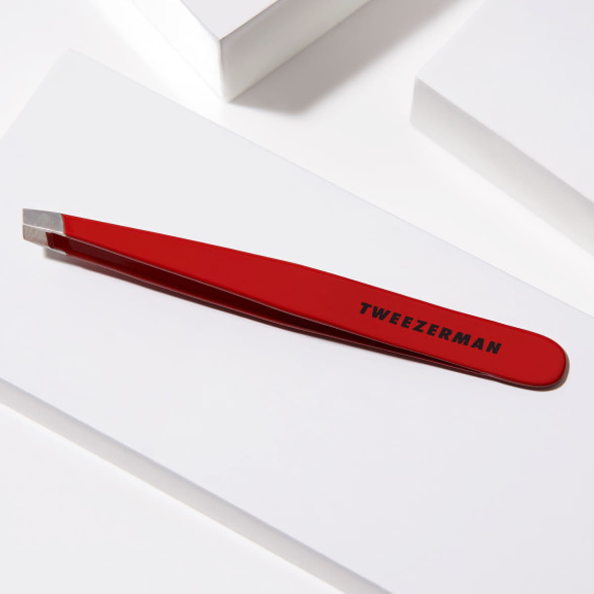 Tweezerman Slant Tweezer - Signature Red (1 pc) - product lifestyle shot shown.