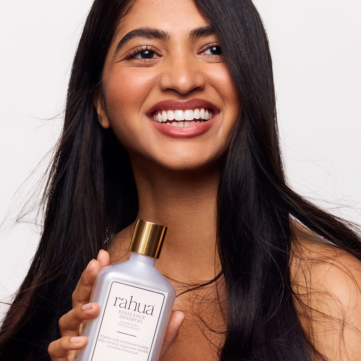 Rahua Rebalance Shampoo (275 ml) - model shown holding product. 