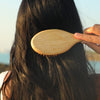 Rahua Enchanted Island Shampoo (275 ml) - model shown brushing hair. 