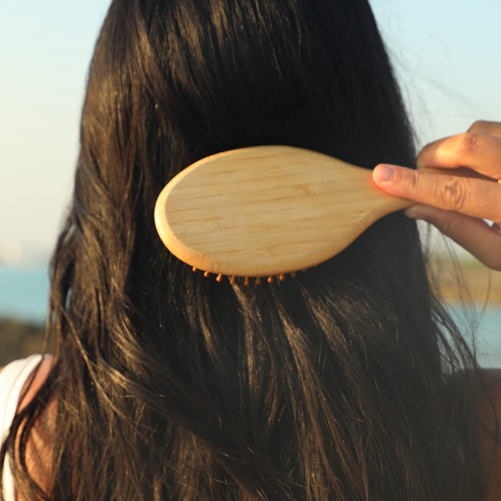 Rahua Enchanted Island Shampoo (275 ml) - model shown brushing hair. 