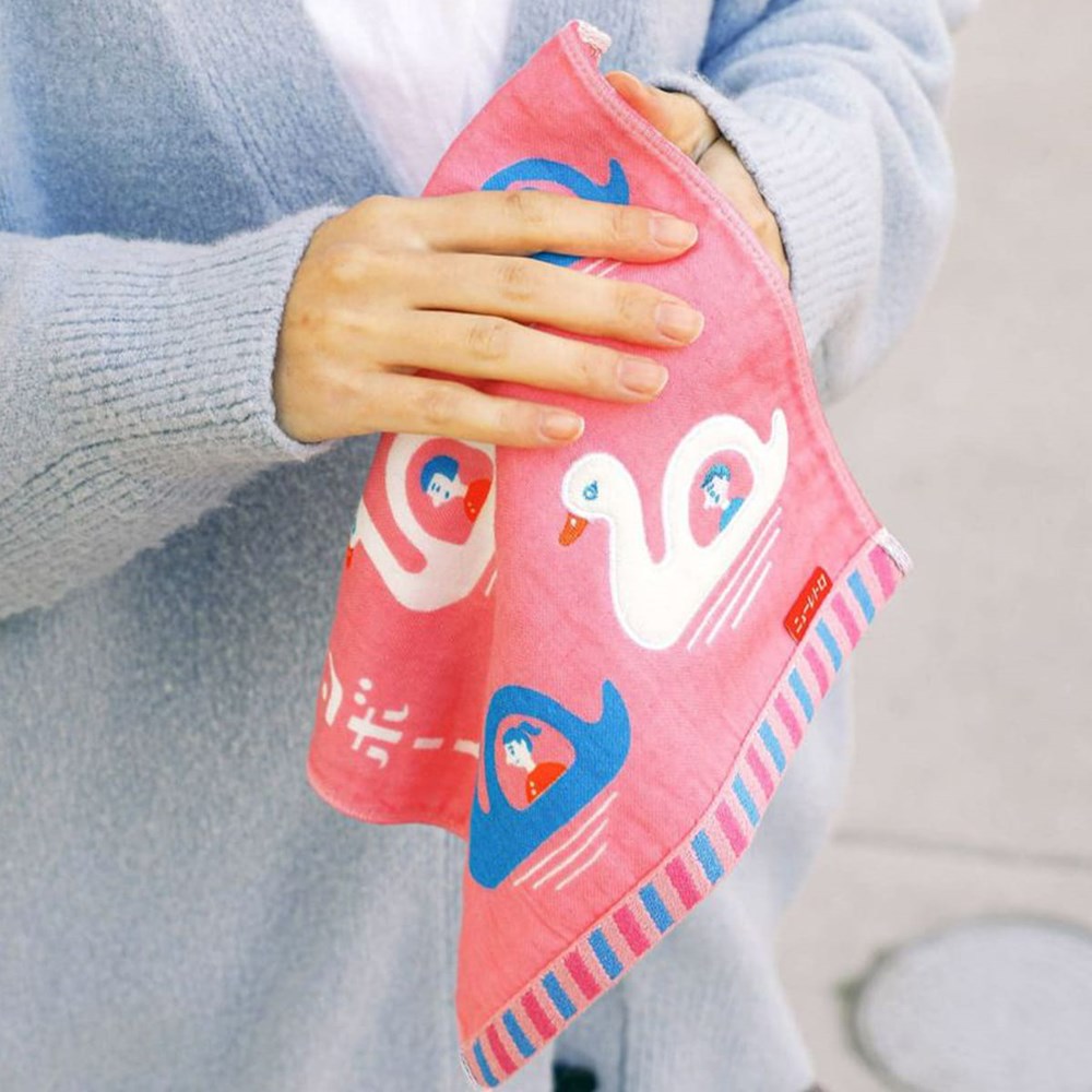 A person holding Hightide Hand Towel - Swan Boat (1 pc)