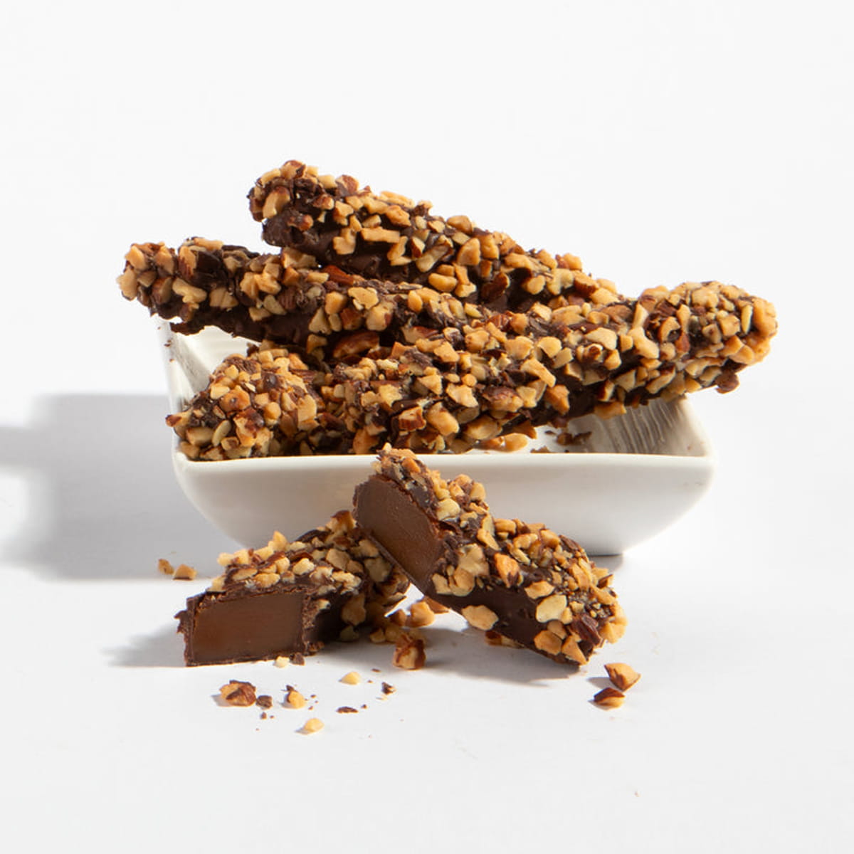 Charles Chocolates Caramel Almond Sticks in a dish with one stick cut in half in the foreground