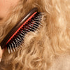 L'Artisan Brossier Pure Boar & Nylon Bristle Brush - Large (1 pc) - product shown brushing blonde hair. 