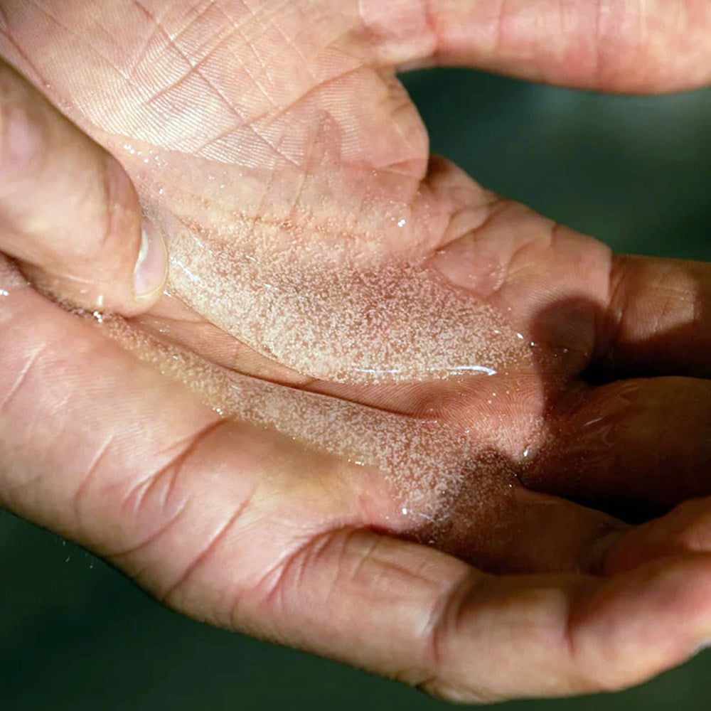 Close-up of a hand holding Naomi After-Cooking Hand Scrub - Wood &amp; Yuzu