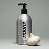 Naomi After-Cooking Hand Scrub - Wood & Yuzu (500 ml) next to a whole garlic bulb