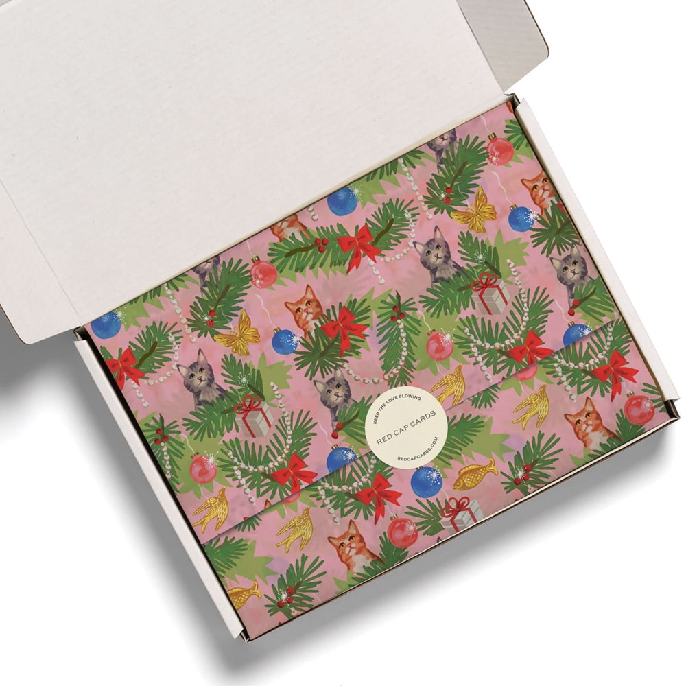 A white cardboard gift box shown open from an overhead angle, revealing Red Cap Cards Meowy Christmas Tissue Paper