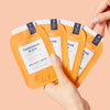 Model holding packets from the VOESH New York Pedi In A Box - Tangerine Glow