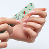 A close-up of hands with manicured pink nails using the holiday theme nail file from the VOESH New York Mini Mani Set