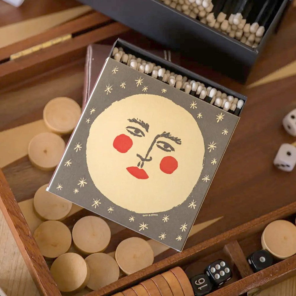 Lifestyle shot of Archivist Moon Matchbox (1 box) with backgammon game in the background