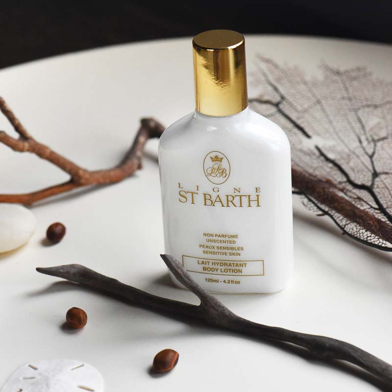 Lifestyle shot of Ligne St. Barth Body Lotion (4.2 oz, Unscented) with branch and black fan coral in the background