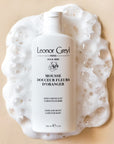 Lifestyle shot top view of Leonor Greyl Mousse Douceur Fleurs D'Oranger (For Baby) (150 ml) with soap suds around bottle