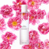 Beauty shot of Chantecaille Pure Rosewater 100 ml with rose de mai flowers in the background