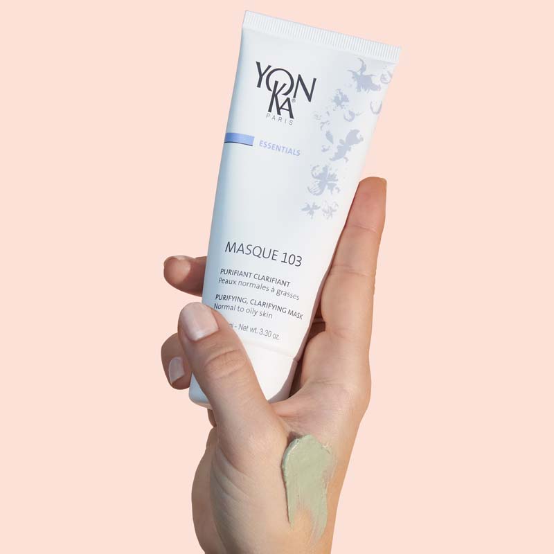 Model holding tube of Yon-Ka Paris Masque 103 (75 ml) with smear of mask on her hand to show color and texture