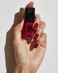 Model with light skin tone wearing and holding bottle of JINsoon Nail Lacquer - Coquette