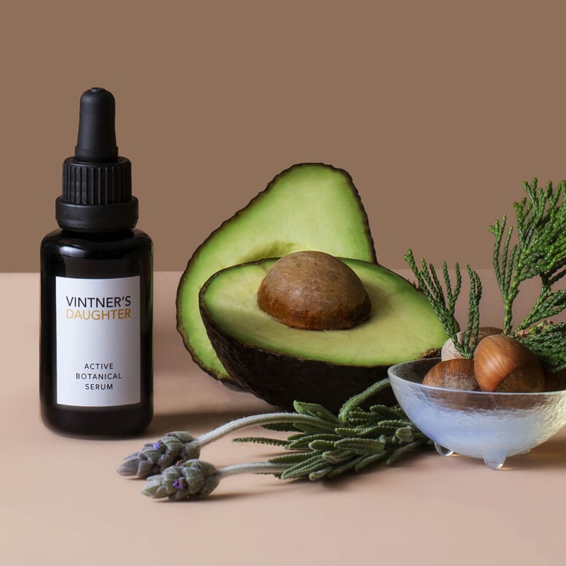 Lifestyle shot of Vintner&#39;s Daughter Active Botanical Serum (30 ml) with avocados and lavender in the background