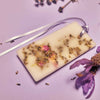 Close up lifestyle shot of Santa Maria Novella Lavender Scented Wax Tablet with lavender in the background