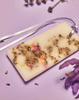 Close up lifestyle shot of Santa Maria Novella Lavender Scented Wax Tablet with lavender in the background