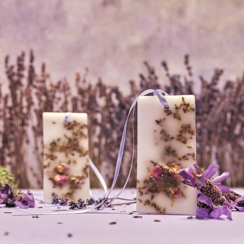 Close up lifestyle shot of Santa Maria Novella Lavender Scented Wax Tablets (2 pcs) with lavender in the foreground and background