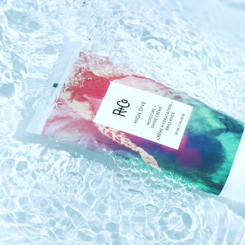 Beauty shot of R+Co High Dive Moisture + Shine Crème - 5 oz tube submerged in water