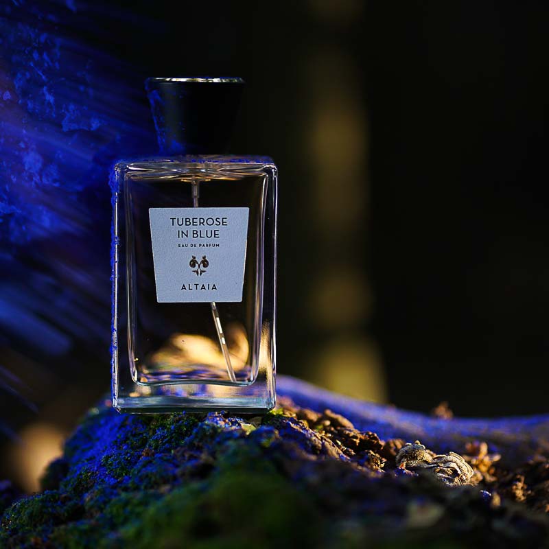 Beauty shot of ALTAIA Tuberose in Blue Eau de Parfum with purple powder in the background