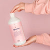 Model holding bottle of Kerzon Fragranced Laundry Soap - Mega Propre (33.34 oz)