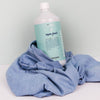 Lifestyle shot of Kerzon Fragranced Laundry Soap - Super Frais (33.34 oz) with denim in the background