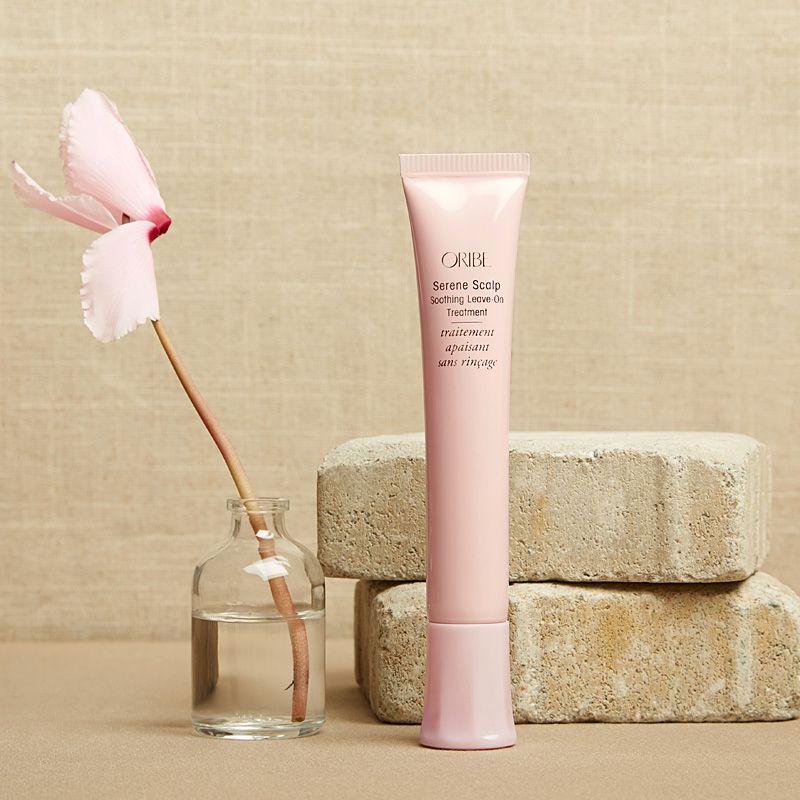 Oribe Serene Scalp Soothing Leave-On Treatment standing by bricks