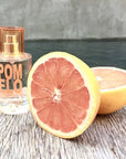 Lifestyle shot of Solinotes Paris Pomelo (Grapefruit) Eau De Parfum  (50 ml) with sliced grapefruit next to bottle