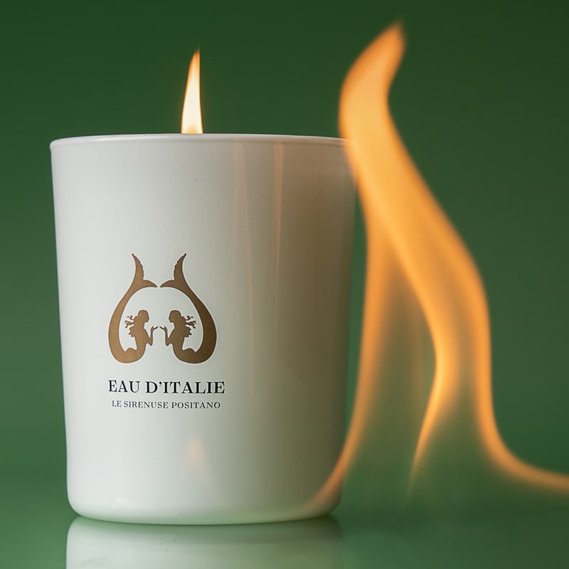 Eau d&#39;Italie Scented Candle (190 g) shown burning with large flame shown next to candle