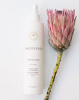 Beauty shot of Innersense Organic Beauty I Create Finish 10 oz with pink flower next to product