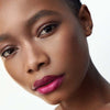 (M)ANASI 7 All Over Color Creamy Finish (5 g, Fuchsine) shown on lips of model with dark skin tone