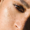 Close up of (M)ANASI 7 Bronzelighter - Roseate (13 g) on model's face