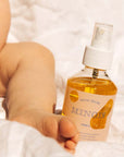 Minois Paris Huile Seche (Dry Oil) (150 ml) with leg of baby in the background