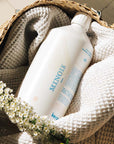 Lifestyle shot of Kerzon Lessive Parfumee (Fragranced Laundry Soap) (1 liter) in basket with blanket in the background