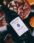 Lifestyle shot of Sangre de Fruta Botanical Hand Wash Neroli Noir (500 ml) top view with oranges and pomegranate in the background