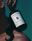 Lifestyle shot of Sangre de Fruta Botanical Shampoo Neroli Noir (500 ml) resting on the shoulder of model