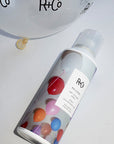 Lifestyle shot of R+Co Balloon Dry Volume Spray (5 oz) shown top view