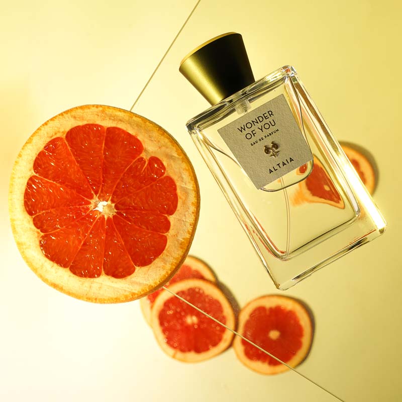 Lifestyle shot of ALTAIA Wonder of You Eau de Parfum (100 ml) with citrus slices in the background