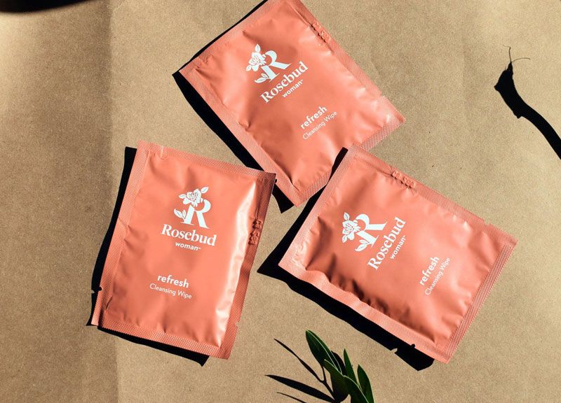 Rosebud Woman Refresh Intimate and Body Cleaning Wipes - beauty shot of 3 packets on sand