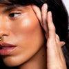 model with olive tone skin wearing NOTO Botanics Hydra Highlighter