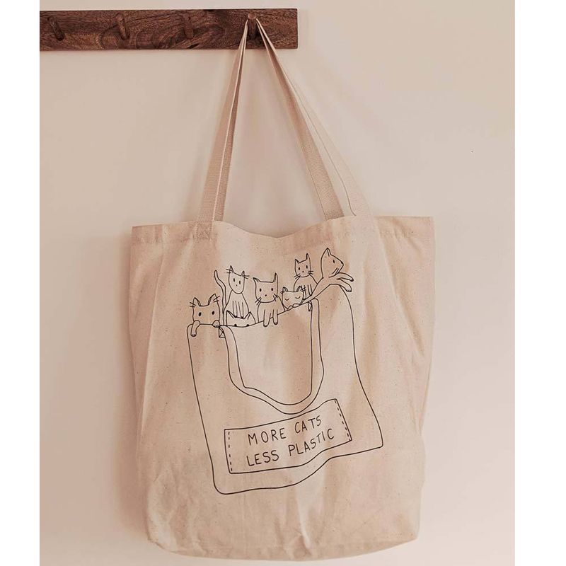 Mimi & August More Cats Less Plastic Printed Cotton Tote Bag hanging on peg