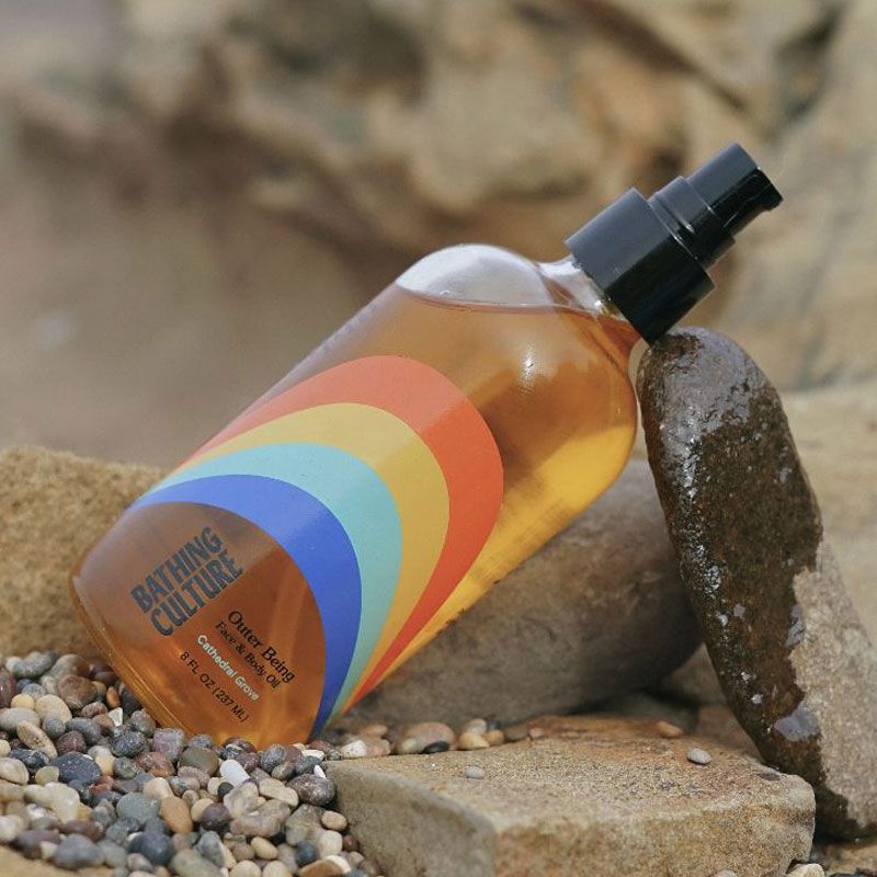 Bathing Culture Outer Being Face &amp; Body Oil - lifestyle shot on the beach with rocks