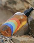 Bathing Culture Outer Being Face & Body Oil - lifestyle shot on the beach with rocks