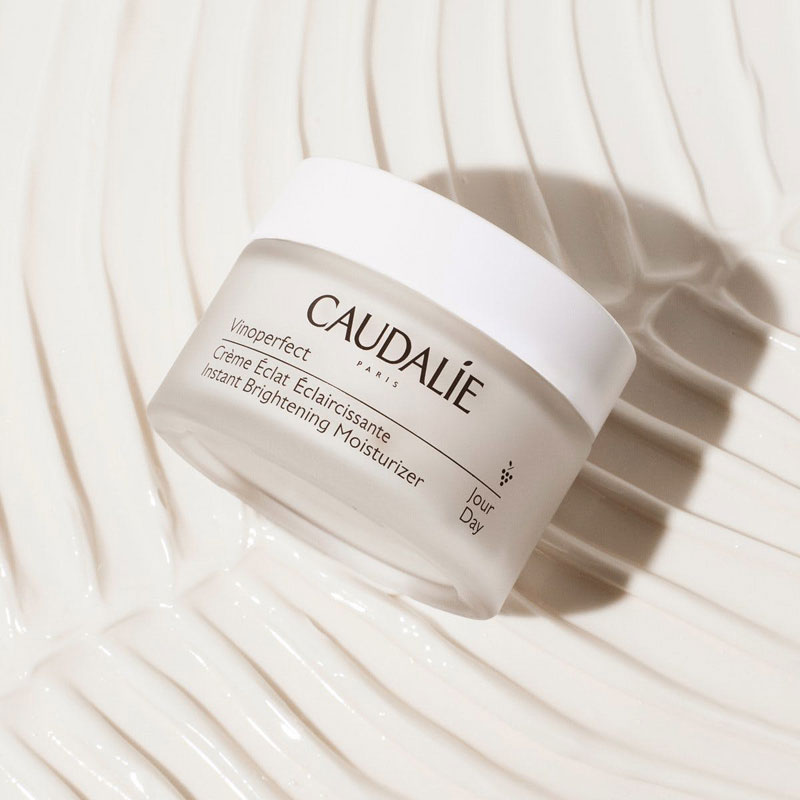 Caudalie Vinoperfect Instant Brightening Moisturizer (50 ml) on a background of product - texturized.