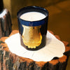 Cire Trudon Ourika Candle lifestyle shot on tree stump