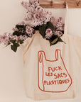 Mimi & August F&$! Plastique French Printed Cotton Tote Bag hanging on a hook with flowers in it