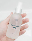Mother Mother Magnesium Oil (4 oz) held in woman's hand