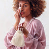 Daily Ritual Bio-Cotton Make Up Remover and Laundry Bag with contents shown by model