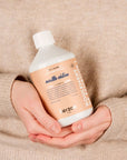 Close up shot of woman holding Kerzon Fragranced Laundry Soap - Maille Caline (16.67 oz)