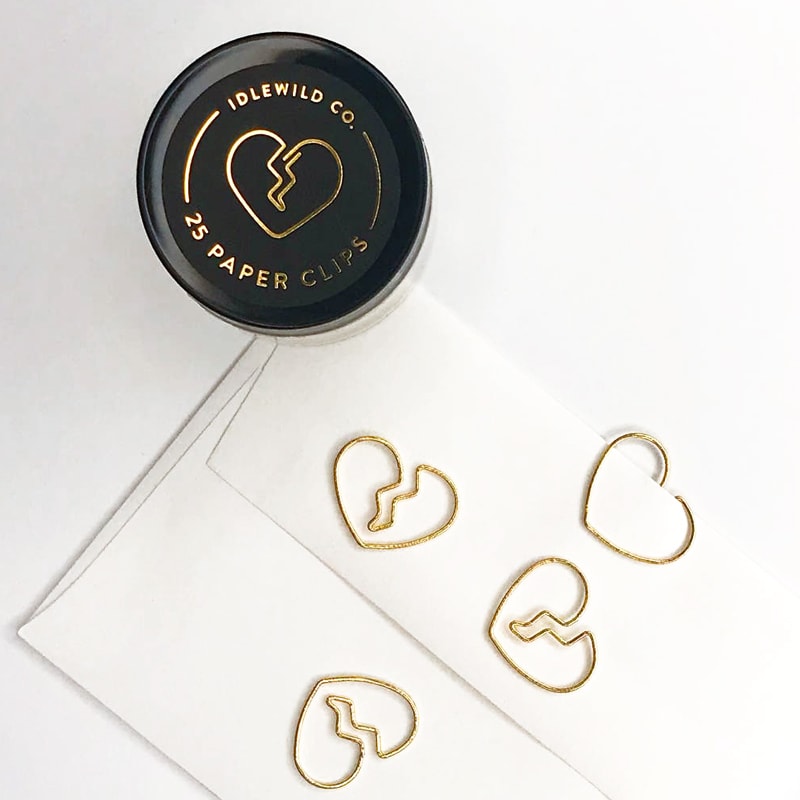 Idlewild Broken Heart Paper Clips (25 pcs) showing top of jar and 4 clips, one of which is clipped to an envelope
